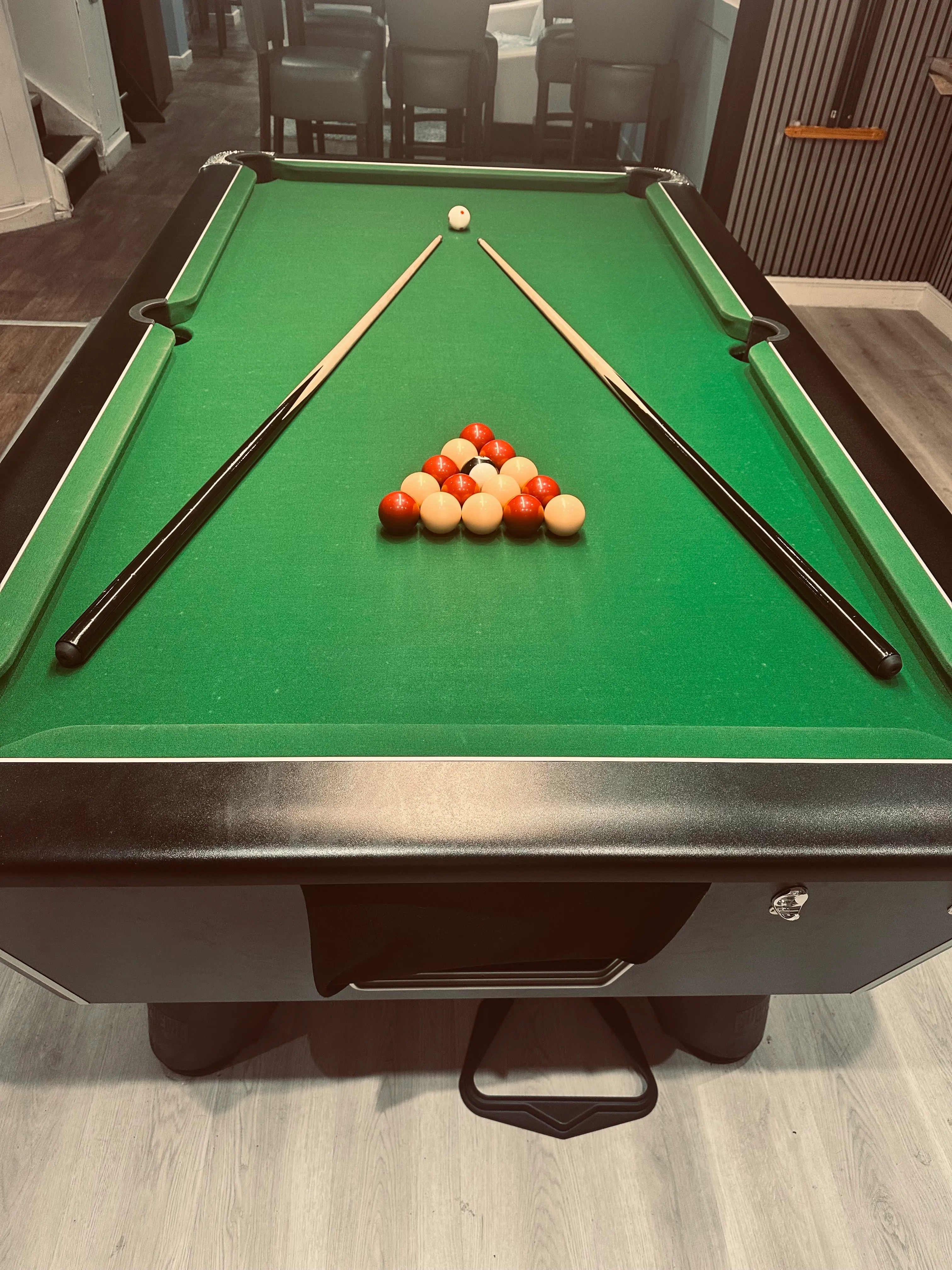 A pool table with a pool ball and cues on it.