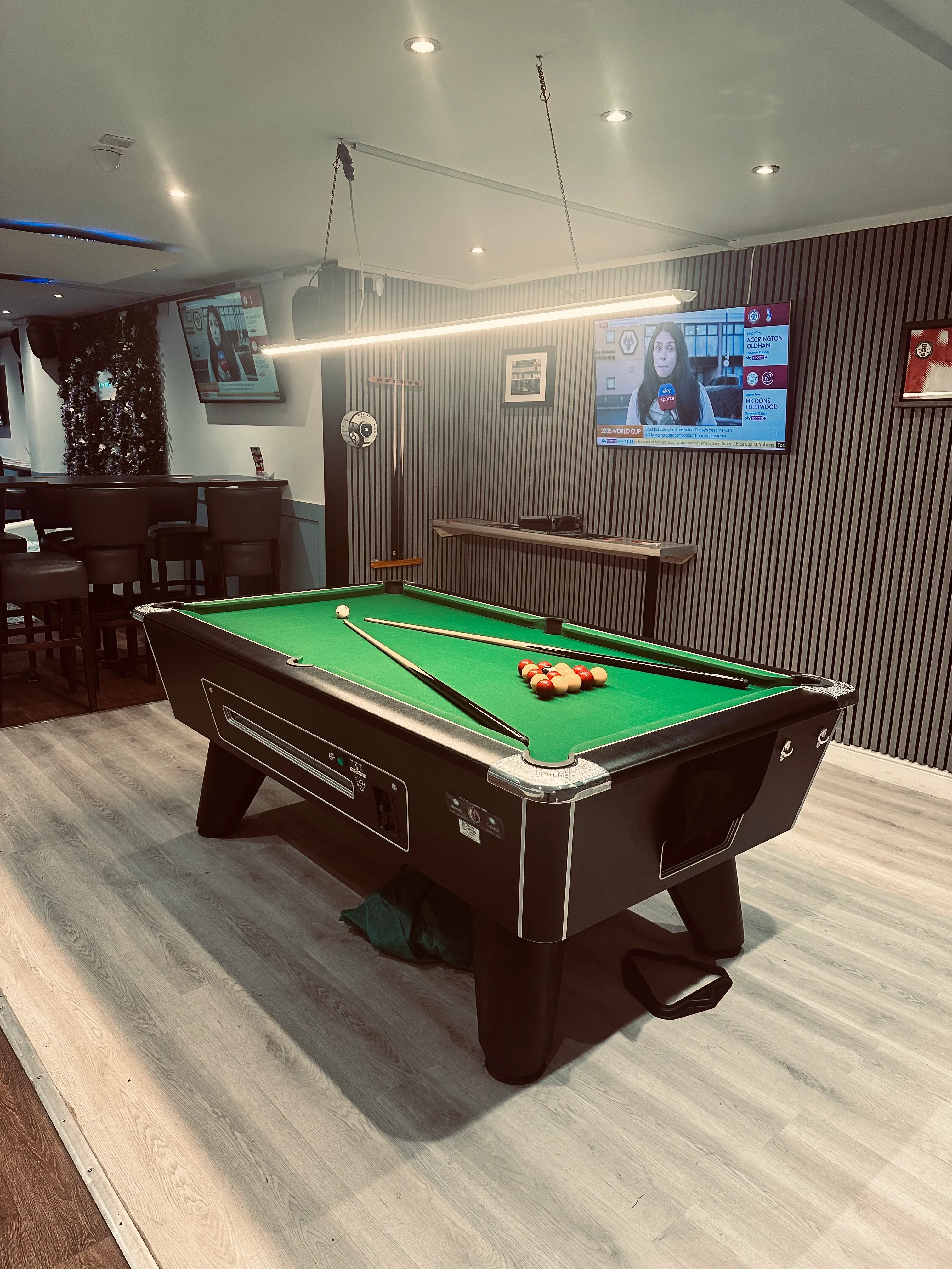 A pool table in a room with a television.